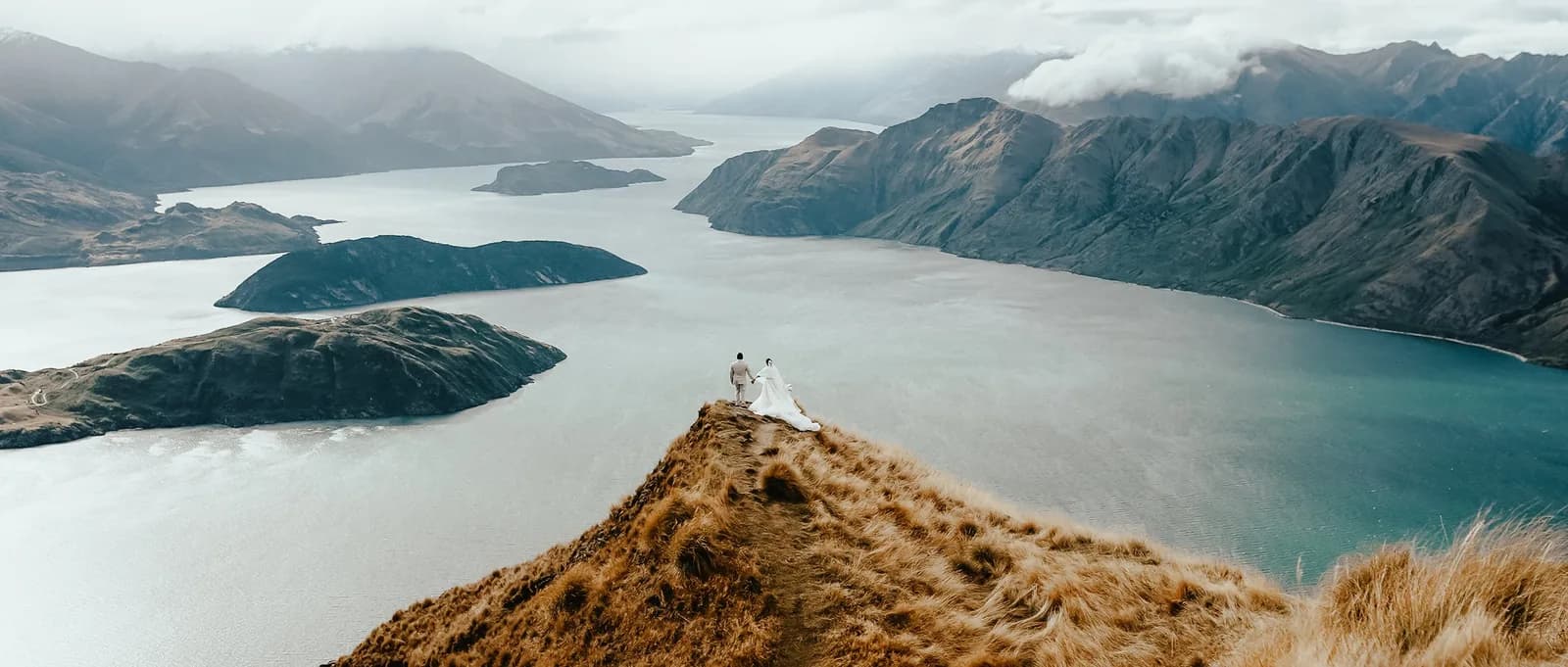 Couple on a ridge overlooking a lake in New Zealand, captured by V Visual